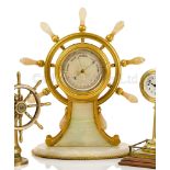 A FINE AND LARGE GILT, BRASS AND AGATE SHIP’S WHEEL DESK BAROMETER, ATTRIBUTED TO BETJEMANN & SONS