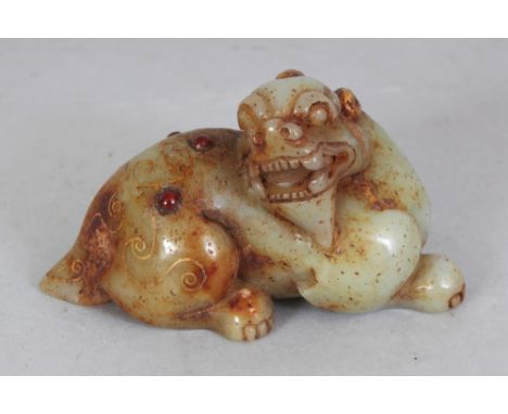 A CHINESE HAN STYLE GILT DECORATED AND BEAD ONLAID JADE MODEL OF A BUDDHISTIC LION, 3.25in long & 1.75in high.