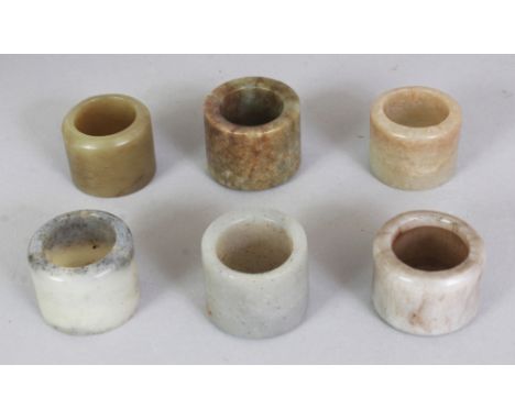 A GOOD GROUP OF SIX CHINESE MING & QING DYNASTY JADE ARCHER'S RINGS, slightly different sizes, the largest one 1.25in diamete