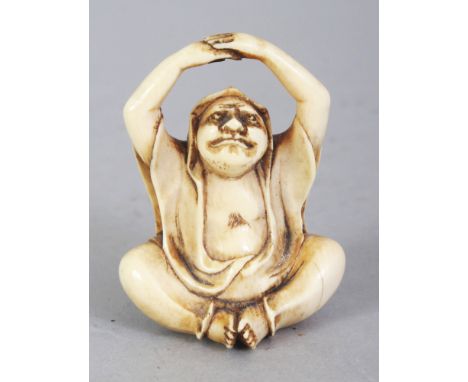 A SIGNED JAPANESE MEIJI PERIOD IVORY NETSUKE OF DARUMA, seated in meditation, his upraised arms forming the himotoshi, the ba