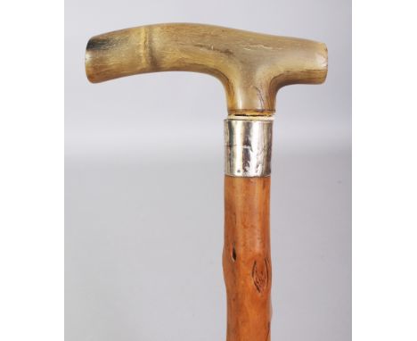 A RHINO HORN HANDLED WOOD CANE, with an engraved silver-metal collar, the knarled wood stick incised 'S.F. 1/1/90', the oblon