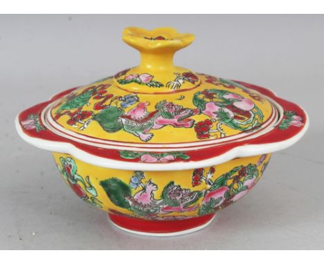 A CHINESE YELLOW GROUND FAMILLE ROSE PORCELAIN BOWL & COVER, with a wavy rim, decorated with peach, ribboned emblems and budd