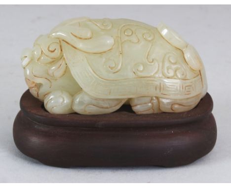 A CHINESE CELADON JADE MODEL OF A DRAGON TURTLE, together with a fitted wood stand, 2.5in high overall, the jade 3.5in long &