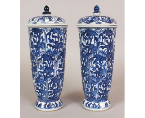 A PAIR OF CHINESE KANGXI STYLE BLUE & WHITE PORCELAIN URNS & COVERS, each decorated with panels of stylised foliage, each bas