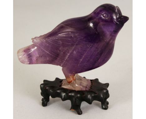 A SMALL CHINESE AMETHYST MODEL OF A STANDING BIRD, together with a fitted wood stand, 3.25in high overall, the bird itself 2.