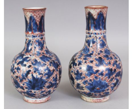 A PAIR OF CHINESE KANGXI PERIOD UNDERGLAZE-BLUE & IRON-RED PORCELAIN BOTTLE VASES, each painted with lotus reserved on a fish