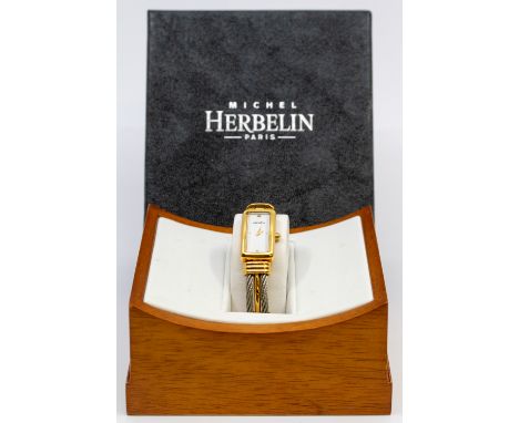 A ladies steel and gold plated wristwatch by  Michel Herbelin, comprising a rectangular signed white dial with gilt indices, 