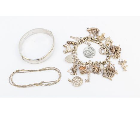 A small collection of silver jewellery to include a vintage charm bracelet with various charms, along with a hollow hinged ba