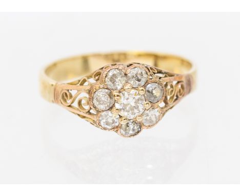 A diamond and gold ring, comprising a flower cluster of old cut diamonds, setting approx 8mm, filigree shoulders, size O1/2, 