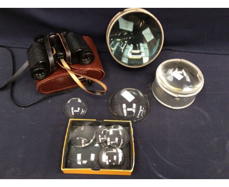 A collection of vintage early 20th century small and large magnifying lenses together with cased binoculars