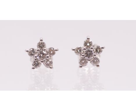 A pair of diamond and platinum flower cluster earrings, comprising round brilliant cut diamonds claw set to a flower cluster 