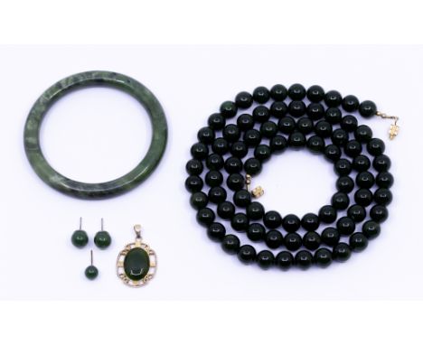 A collection of nephrite jade to include a necklace of a inform row of round beads, each approx 8mm, length approx 32'', alon