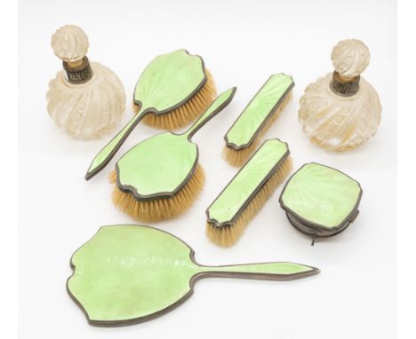 A George V silver and green guilloche enamelled dressing table set consisting of two hand brushes, two smaller brushes, lidde