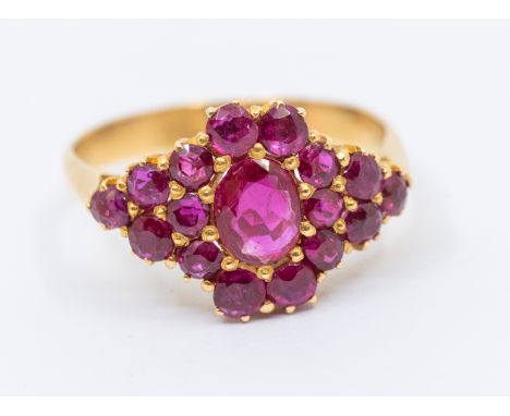 A ruby and 18ct gold ring, comprising a central oval mixed cut ruby approx 4 x 6mm, within a border of round mixed cut rubies