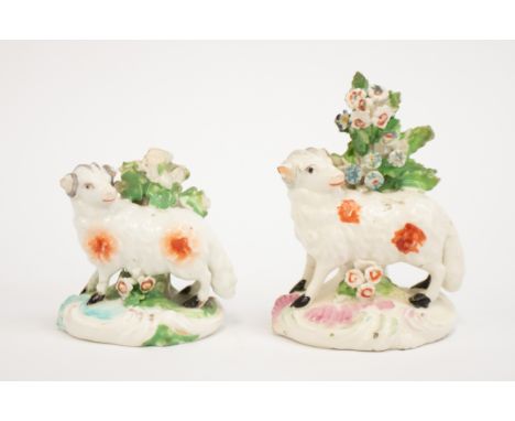 Two Derby porcelain figures of rams standing next to foliage, both once part of a pair, both with Derby factory patch marks. 