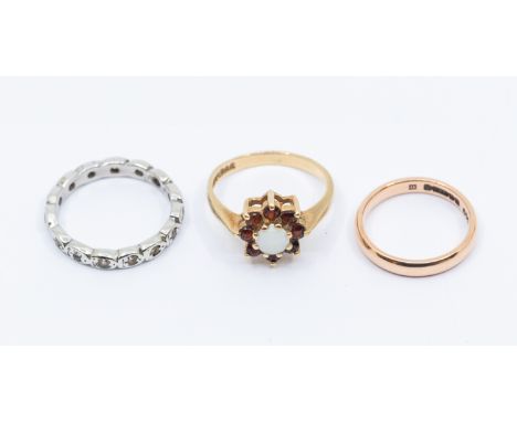 A collection of three 9ct gold rings to include an opal and garnet cluster, claw set, size N,  along with a 9ct rose gold ban