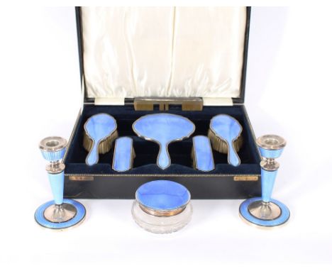 A cased silver and enamel decorated dressing table set, with matched candlesticks and similar powder bowl