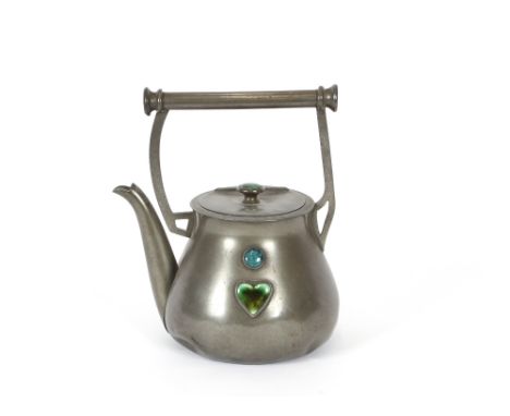 An Arts &amp; Crafts design pewter kettle, having angular handle, the body and lid inset with enamel decorated panels, 21cm h