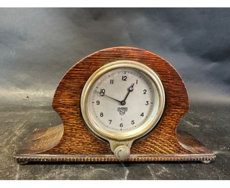 A Smiths dashboard clock mounted into a wooden mantle case. 