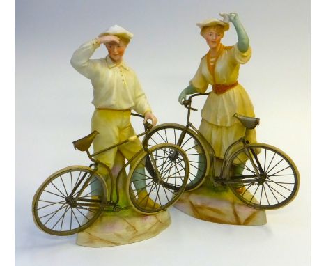 A pair of  Gebruder Heubach. 'Bisque' figurines of a boy and girl bicycle riders with carefully crafted metal Safety Bicycles