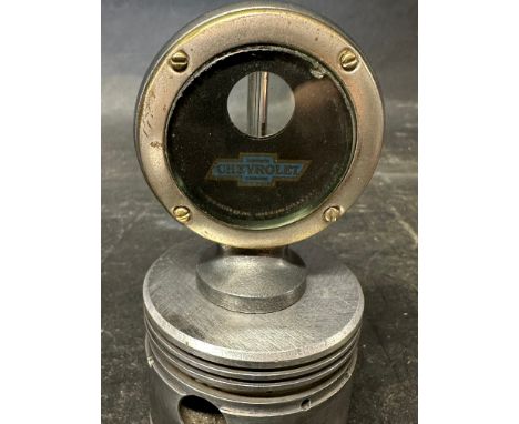 A Chevrolet Boyce moto-meter mounted upon a piston for display purposes, by repute in working order. 