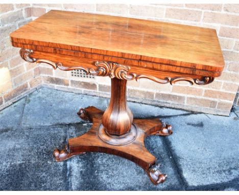 AN EARLY VICTORIAN ROSEWOOD CARD TABLE  with carved decoration, on octagonal inverted baluster pillar and quatrefoil base, 91