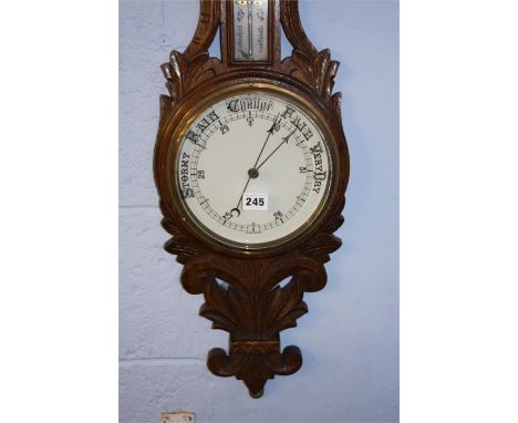 A carved oak barometer.