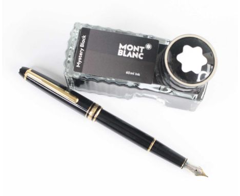 A Montblanc Meisterstück fountain pen, black resin with gold-coated trim, the cap with white star emblem to tip of cap and en