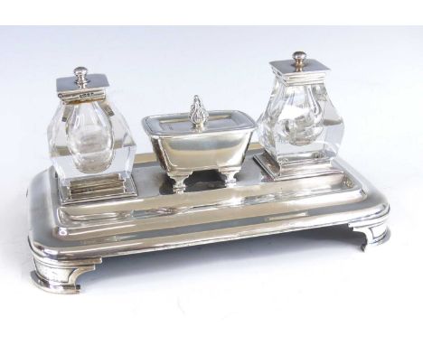 An early Victorian silver desk stand, of rounded rectangular form raised upon four architectural curved feet, comprising two 