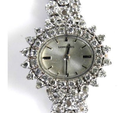 A white metal lady's diamond set Longines manual wind cocktail watch, with oval silver baton dial and two rows of 20 single c
