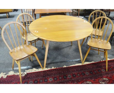 An Ercol 384 design round blonde drop leaf dining table; a set of four stick back dining chairs, one baring the blue Ercol la