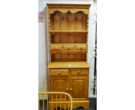 A Farmhouse pitch pine dresser of slim proportions, single shelf above three spice drawers, two small drawers to base above f