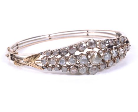 An Antique Rose Cut Diamond Bangle:The unhallmarked gold hinged bangle comprising three layered bands and with leaves to the 