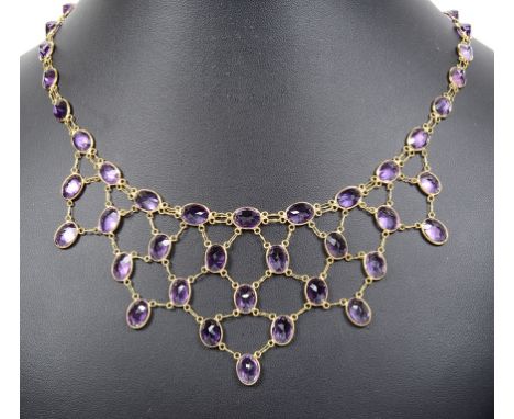 A 14ct Amethyst Frill Necklace.Oval cut amethysts set in frill pattern with full set amethysts to the chain, on an S link cla