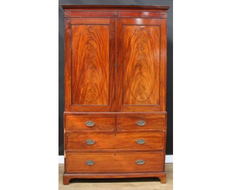 A 19th century mahogany linen press, outswept cornice above a pair of panel doors enclosing three sliding trays, the base wit