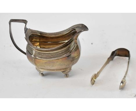 A George III hallmarked silver cream jug, London 1815, also a pair of silver sugar tongs, combined approx 8ozt/249.6g (2).