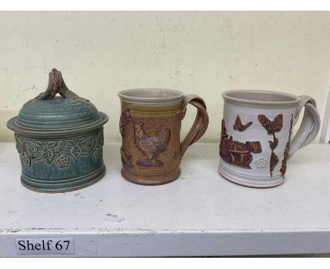 Two studio ceramic mugs and a blue lidded glazed studio ceramic lidded pot, all indistinctly signed and dated 1952 to base (3