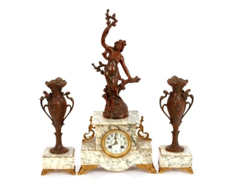 A French Art Nouveau style marble and spelter mantel clock with matching garnitures