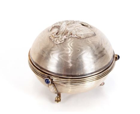 A silver musical box, of circular form, the lid decorated with an angel, inscribed to the gilded interior "Oh Come All Ye Fai