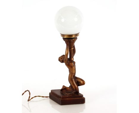 An Art Deco style lamp, in the form of a kneeling naked lady holding an opaque glass shade, 33cm high 