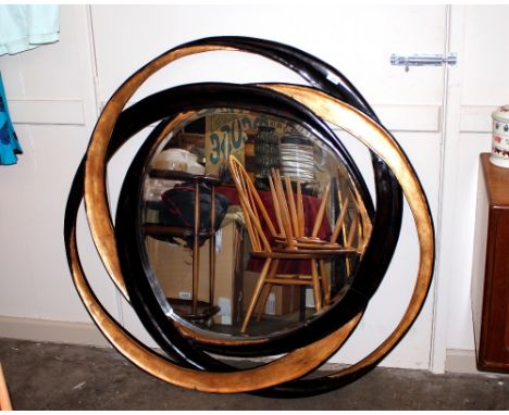 A large ebonised and gilt modern design circular wall mirror, 118cm dia. overall