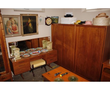 A teak Austin suite, dressing table with mirror back and drawers below; and a matching gentleman's and ladies wardrobe