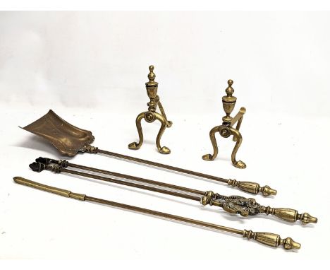 A pair of early 20th century brass firedogs, with early 20th century brass fire tools. 