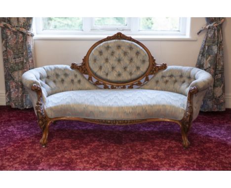 VICTORIAN FLORAL CARVED WALNUT SHEW-WOOD FRAMED DRAWING ROOM SETTEE, BUTTON UPHOLSTERED IN BLUE AND GOLD WOVEN FABRIC, HAVING