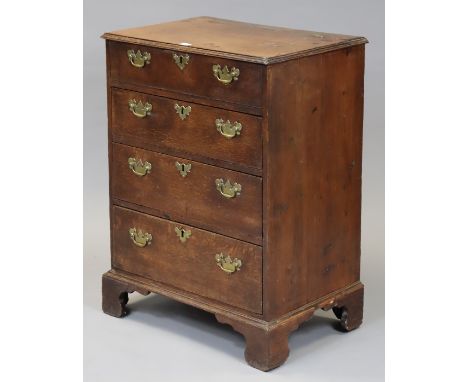 A 19th century oak small chest with a hinged lift top, having a mock drawer above three long drawers with brass swing handles