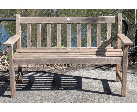 A teak slatted garden bench on four square legs with plain stretchers, 127.5cm wide.