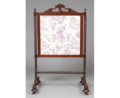 A 19th century mahogany fire screen inset with a painted cloth panel, on bobbin-turned supports &amp; turned feet with cerami