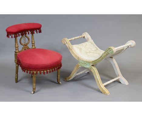 A 20th century Empire-style painted pine stool with carved decoration, turned supports &amp; padded seat, 75cm long x 55cm hi