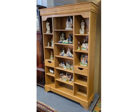 A light oak tall standing open bookcase fitted fourteen shelves &amp; two small drawers, &amp; on bracket feet, 130cm wide x 