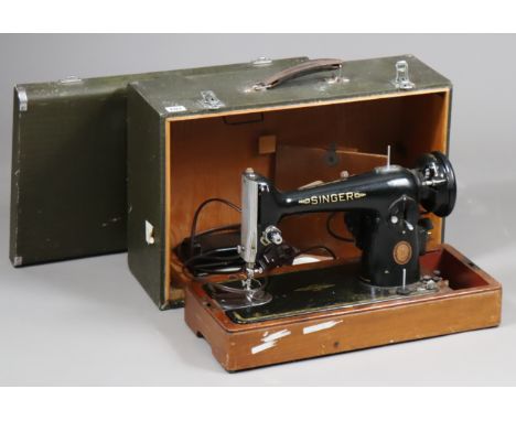 A vintage Singer electric sewing machine with carrying case. 